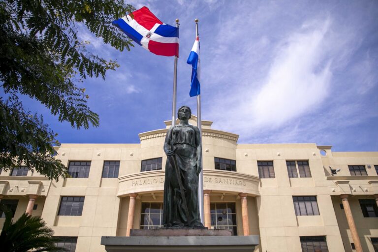 SANTIAGO (República Dominicana). – Respondiendo a una solicitud del Ministerio Público en Santiago, los jueces del Cuarto Tribunal Colegiado de este distrito judicial condenaron a 20 años de prisión a cada uno de los miembros de la estructura criminal de narcotraficantes a los cuales el organismo persecutor ocupó más de 2 mil libras de marihuana, cocaína, armas, prendas, y dinero en efectivo, durante un operativo interagencial desarrollado en el año 2023. Por el alijo fueron detenidos en flagrancia los condenados José Andrés Rodríguez Guzmán y Ángelo José Rodríguez Rodríguez, quienes integraban una estructura criminal cuyas operaciones se extendían por comunidades del norte del municipio Santiago de los Caballeros. Validando la multiplicidad de pruebas materiales, periciales y documentales que la Fiscalía de Santiago puso a su disposición, el tribunal condenó a Rodríguez Guzmán y a Rodríguez Rodríguez a cumplir 20 años privados de su libertad y a pagar una multa de cinco millones de pesos en efectivo (RD$ 5,000,000), en favor del Estado dominicano. La fiscal Jenniffer Rodríguez, haciendo uso del pliego de pruebas recolectadas durante la etapa de investigación, manifestó ante el tribunal, integrado por los magistrados Rubén Rodríguez, Rubén Darío Cruz Uceta y Jasmín de los Santos, que la organización dedicada al tráfico a gran y mediana escala de drogas operaba bajo una inusual modalidad a fin de evadir las labores de vigilancia y rastreo de la droga. Estas diligencias de investigación, que precedieron a la operación, lograron constatar el nivel de experticia que tenían los traficantes para simular que la sustancia eran rollos de tela. Sobre la operación interagencial que el Ministerio Público coordinó y en la que participaron agentes antinarcóticos de la Dirección Nacional de Control de Drogas (DNCD), a través de la Dirección de Operaciones Contra el Tráfico de Drogas para el Consumo Interno (Dotci), las autoridades lograron incautarse de 400 pacas con un peso aproximado de 2,227 libras de marihuana. Además, se incautaron de un kilogramo de cocaína, confirmado por los análisis forenses practicados por el Instituto Nacional de Ciencias Forenses (Inacif). A la estructura se le ocuparon, también, dos armas de fuego tipo pistola, una Carandai y una Taurus, calibre nueve milímetros; una escopeta Maverick calibre 12 milímetros con 14 cartuchos, así como decenas de cápsulas de distintos calibres. Entre las pruebas materiales había, además, prendas, dos balanzas digitales utilizadas para el pesaje de la droga, una máquina trituradora, y una máquina para empaque al vacío. Partes de las pruebas materiales que el Ministerio Público ocupó evidenciaron un método sofisticado para la envoltura, almacenaje, distribución y venta de distintos tipos de drogas, en rollos de plástico y material textil sintético. Las condenas se basan en la violación a los artículos 4 (letra D), en la categoría de traficantes; 5 (letra A), 6 (letra A), 8, 9 (letras D y F), 28, 29, 34, 58 (letras A, B y C) y 75 párrafo II de la Ley 50-88 sobre Drogas y Sustancias Controladas de la República Dominicana. Los procesados también fueron hallados culpables de violación a los artículos 66 y 67 de la Ley 631-16 para el Control y Regulación de Armas, Municiones y Materiales Relacionados.