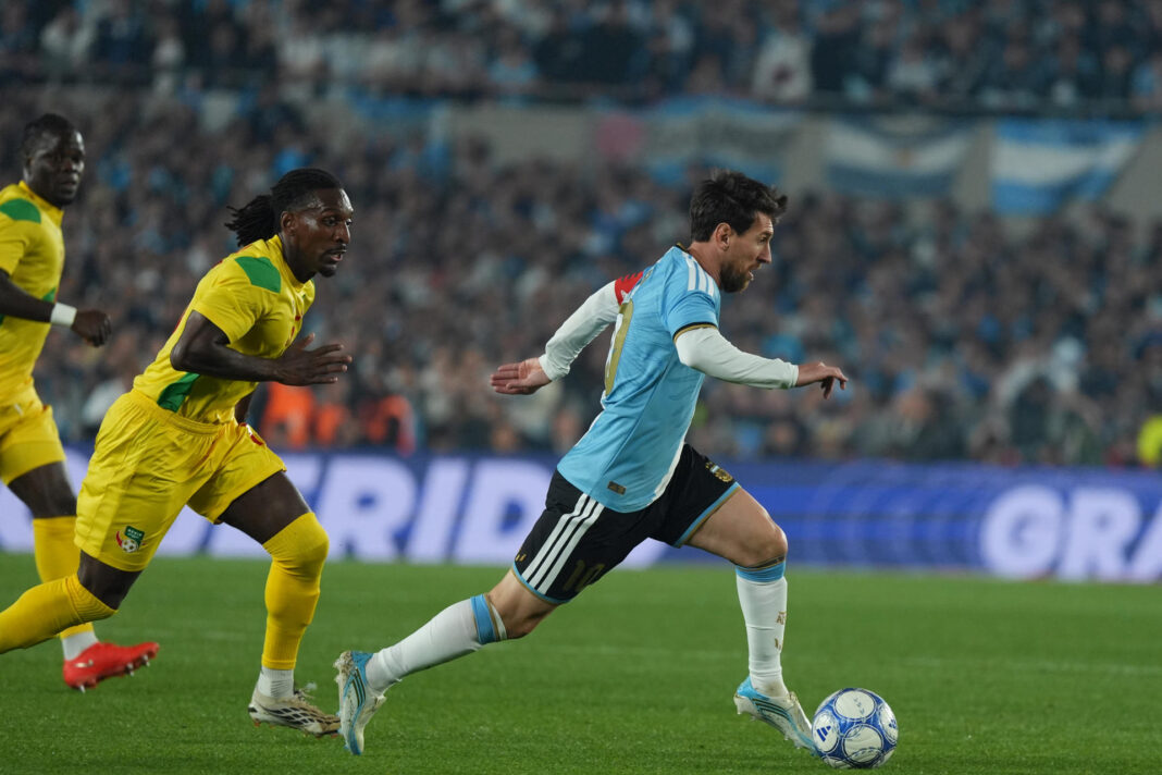Antes del descanso Messi tuvo 4 oportunidades, Benín 2 y el partido paró en el minuto 10 Lionel Messi merodeó el gol en cuatro oportunidades antes del descanso de su partido de despedida, que en el minuto 10 paró por decisión del árbitro chileno Fernando Véjar para permitir la ovación de 85.000 hinchas al capitán. El encuentro, lleno de nostalgia acumulada en 21 años de historia de Messi, pudo aumentar la cuenta de sus goles con la selección en los minutos 6, 23, 26 y 32, en jugadas en las que tuvieron protagonismo Enzo Fernández, Rodrigo De Paul y Lautaro Martínez, así como el portero Marcel Dandjinou. Antes de la media hora, en el minuto 26, Dandjinou negó al capitán un gol de tiro libre. El estadio Monumental ha sido colmado en sus gradas con 85.000 hinchas para un partido que será recordado por su carácter histórico. Veintiún años de historia con la selección Albiceleste, seis títulos y 125 goles resumen la carrera del diez nacido hace 39 años en Rosario. A pesar del dominio del equipo dirigido por Lionel Scaloni, la selección africana tuvo dos oportunidades de gol que pudieron aguar la fiesta. El delantero del Lorient francés Aiyegun Tosin dio el primer aviso a la selección local en el minuto 16 al ganar en el salto a la defensa y conectar de cabeza un lanzamiento que se fue desviado por poco de la portería de Emiliano 'Dibu' Martínez. Dos minutos después, el equipo Albiceleste perdió el control en la banda izquierda y el centrocampista Junior Olaitan ganó la marca a Nicolás Otamendi y remató de primera. La pelota salió rozando el vertical de Martínez.